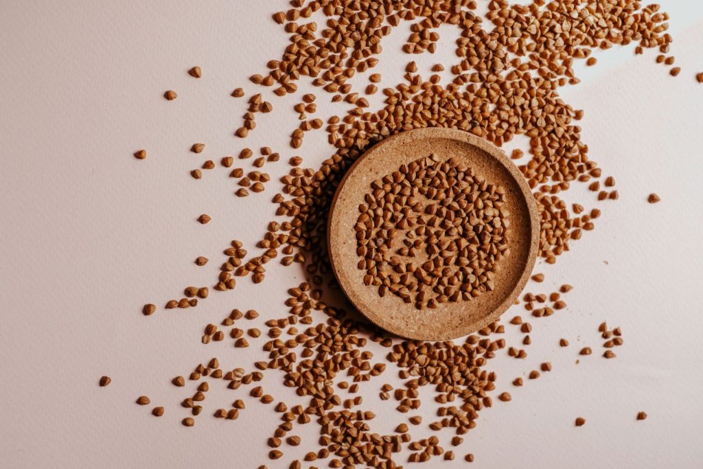 Buckwheat grains on a wooden plate.